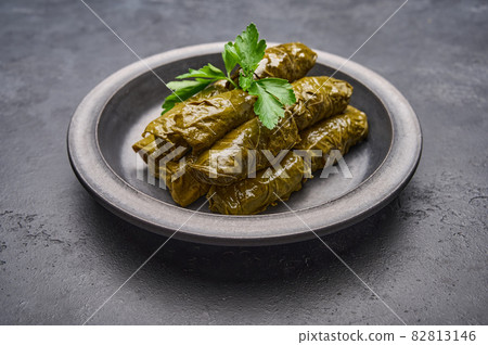 Traditional Middle Eastern dish dolma or tolma, with parsley in black plate Traditional Middle Eastern dish dolma or tolma, with parsley in black plate 82813146