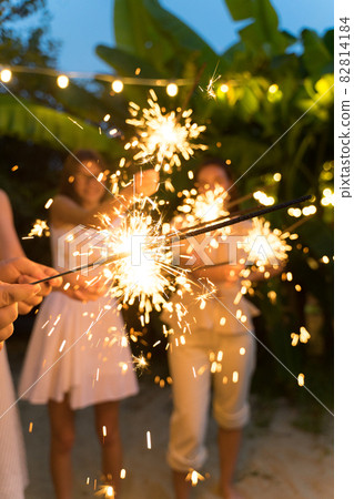 Close-up, friends holding sparklers. Weekend celebrations, fireworks burning with sparks Close-up, friends holding sparklers. Weekend celebrations, fireworks burning with sparks 82814184