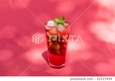 Summer Berry fruit iced tea with ice cubes against rose abstract background. Summer Berry fruit iced tea with ice cubes against rose abstract background. 82815494