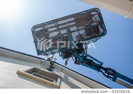 Worker on a aerial access platform, cherry picker, cleaning house 82816016