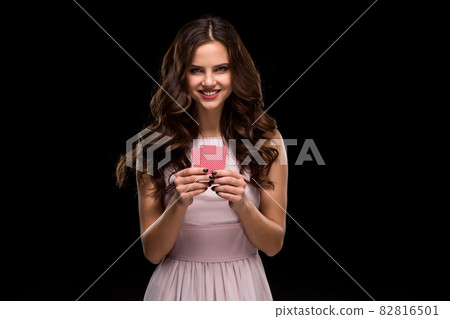Beautiful confident woman showing poker cards looking at camera with copy place Beautiful confident woman showing poker cards looking at camera with copy place 82816501