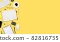 flat lay workspace table with laptop computer, office supplies, coffee cup, tablet and cell phone on yellow pastel background 82816735