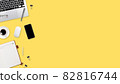 flat lay workspace table with laptop computer, office supplies, coffee cup, tablet and cell phone on yellow pastel background 82816744