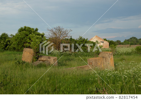Concrete ruins on the site of an abandoned agricultural complex. Ruins overgrown with grass. Landscape. Concrete ruins on the site of an abandoned agricultural complex. Ruins overgrown with grass. Landscape. 82817454