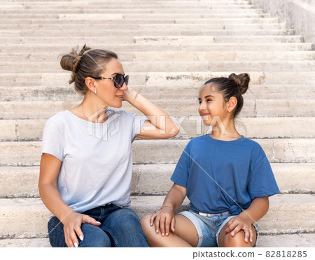 Mother and daughter sitting on the stone stairs outdoor Mother and daughter sitting on the stone stairs outdoor 82818285
