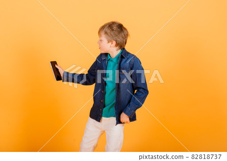 Grimacing emotional redhead fasion boy posing in yellow studio 82818737