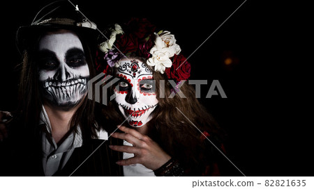 Woman in santa muerte costume and man in skeleton bodypainting for halloween. 82821635