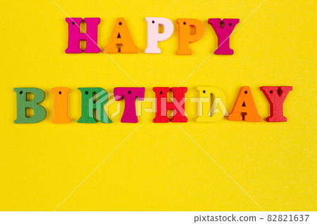 Happy birthday slogan template with copy space for text with name on bright yellow background. Greeting Birthday card with colorful letters. Original congratulations and wishes on the holiday. Closeup 82821637