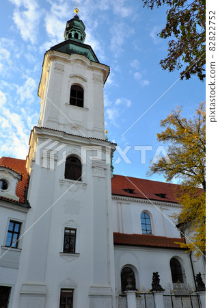 The bell tower of the Strahov Monastery against the blue sky in autumn. 82822752