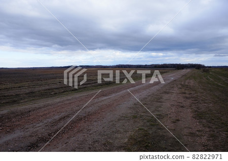 A dirt road among the fields in the evening. Autumn landscape. 82822971