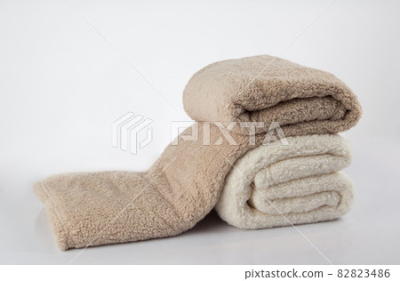 Soft and warm stack of folded blankets isolated on white background Soft and warm stack of folded blankets isolated on white background 82823486