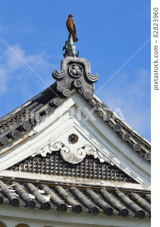 Looking up at the southwest corner turret of Nijo Castle in Kyoto on a clear autumn morning, the black kite takes a rest 82823960