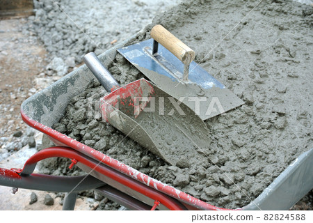 MALACCA, MALAYSIA -FEBRUARY 05, 2016: Fresh wet concrete is poured in wheelbarrow MALACCA, MALAYSIA -FEBRUARY 05, 2016: Fresh wet concrete is poured in wheelbarrow 82824588