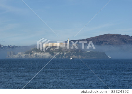 SAN FRANCISCO, CALIFORNIA, UNITED STATES - NOV 25th, 2018: Alcatraz prison in fog panorama during a sunny day in November as seen from pier 39 SAN FRANCISCO, CALIFORNIA, UNITED STATES - NOV 25th, 2018: Alcatraz prison in fog panorama during a sunny day in November as seen from pier 39 82824592