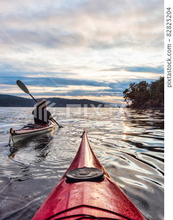 Adventurous Woman on Sea Kayak paddling in the Pacific Ocean. Adventurous Woman on Sea Kayak paddling in the Pacific Ocean. 82825204