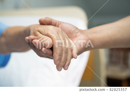 Holding hands Asian senior or elderly old lady woman patient with love, care, encourage and empathy at nursing hospital ward, healthy strong medical concept 82825357