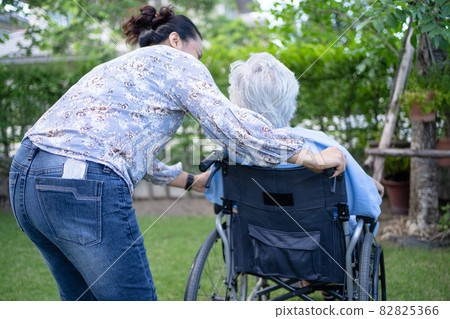 Doctor help and care Asian senior or elderly old lady woman patient sitting on wheelchair at park in nursing hospital ward, healthy strong medical concept. 82825366