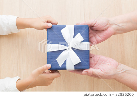 Children giving presents and seniors receiving them 82826200