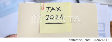Businessman holds in hands folder with documents for filing tax return 82826612