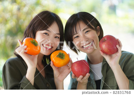 Woman with apple and persimmon 82831768