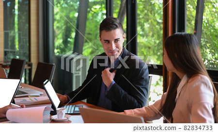 Handsome man business leader explaining some information to his colleagues. Handsome man business leader explaining some information to his colleagues. 82834733