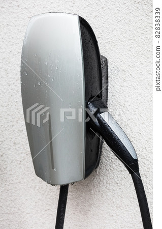 station charging an electric car on white wall station charging an electric car on white wall 82838339