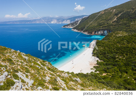 Stunning view of Fteri beach with white sailboat in hidden bay, Kefalonia, Greece. Surrounded by mediterranean vegetation. trekking path. Amazing seascape 82840036
