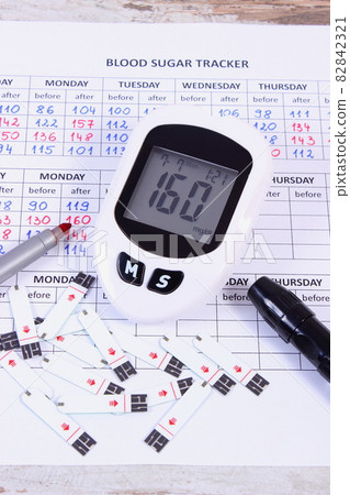 Glucometer and pen on medical form, measuring sugar level 82842321