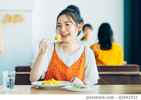 Young woman eating out at a restaurant Young woman eating out at a restaurant 82842332