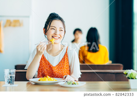 Young woman eating out at a restaurant Young woman eating out at a restaurant 82842333