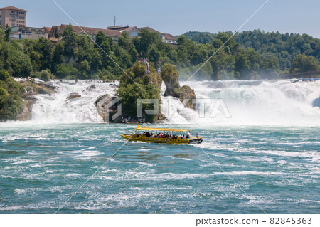 Boat with people floating to the waterfall the Rhine Falls Boat with people floating to the waterfall the Rhine Falls 82845363