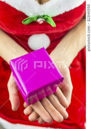 Miss santa holding christmas present Miss santa holding christmas present 82846898