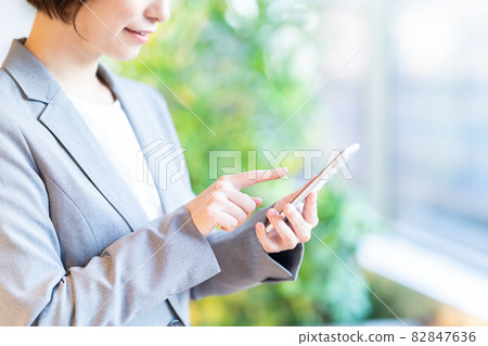 Career woman operating a smartphone (parts) Shooting cooperation: WEEK Shibadaimon (Sun Frontier Fudousan) 82847636