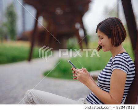 woman in modern park spending her break time woman in modern park spending her break time 82847818