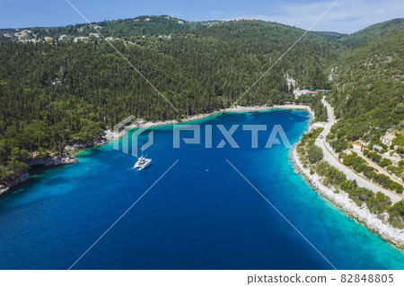 Panoramic aerial view of Foki Beach and sailing yacht boats moored in turquoise bay. Fiskardo, Kefalonia island, Greece 82848805