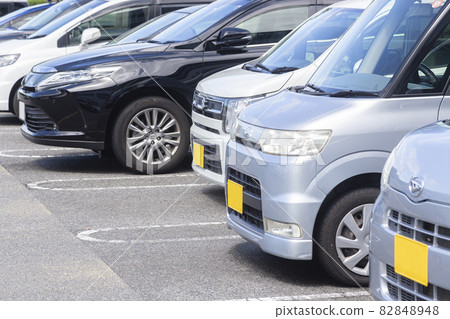 Cars lined up in a parking lot 82848948