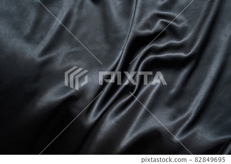 Black silk background. Satin fabric texture. Dark elegant rich backdrop 82849695