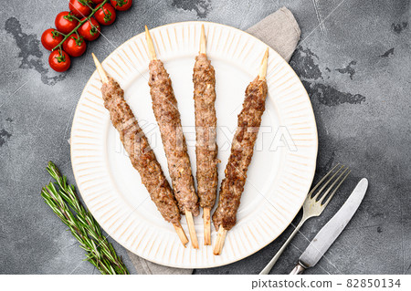 Lula kebab on skewers, on plate, on gray stone table background, top view flat lay 82850134