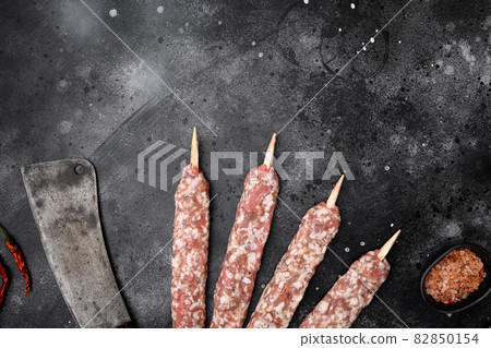 Lyulya kebab, meat dish for cooking, on black dark stone table background, top view flat lay, with copy space for text Lyulya kebab, meat dish for cooking, on black dark stone table background, top view flat lay, with copy space for text 82850154