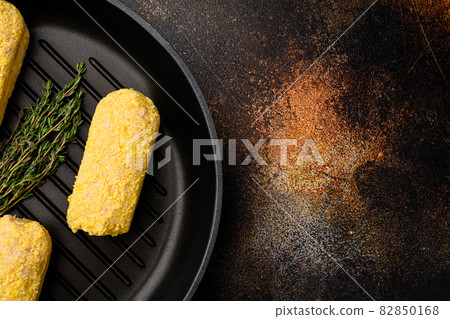 Raw Wiener Schnitzel, breaded, on frying cast iron pan, on old dark rustic table background, top view flat lay, with copy space for text Raw Wiener Schnitzel, breaded, on frying cast iron pan, on old dark rustic table background, top view flat lay, with copy space for text 82850168