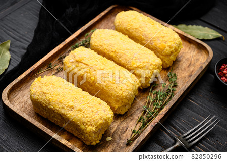 Breaded chicken patty, on black wooden table background Breaded chicken patty, on black wooden table background 82850296
