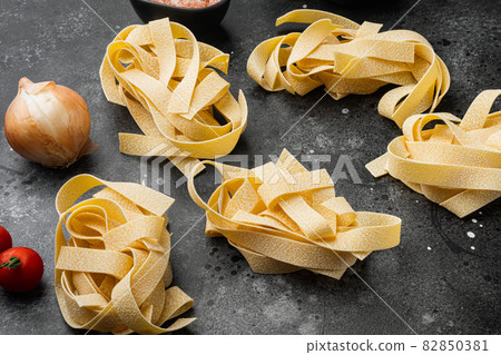 Italian food ingredients pasta, on black dark stone table background Italian food ingredients pasta, on black dark stone table background 82850381