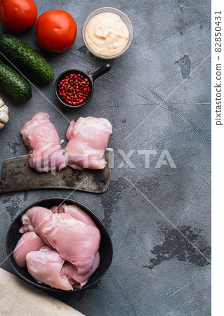 Raw gyros ingredients, chicken thighs on grey background, flat lay with copy space 82850431