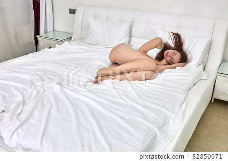 Graceful caucasian woman lies in bed and sleeps. Graceful caucasian woman lies in bed and sleeps. 82850971
