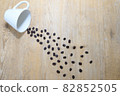 Coffee beans flowing out of the cup 82852505