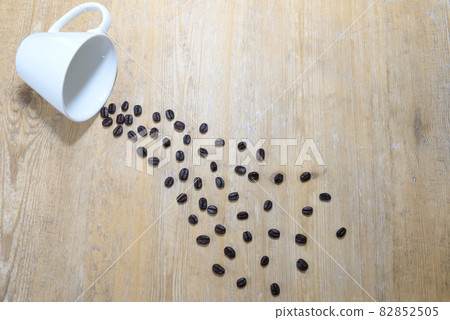 Coffee beans flowing out of the cup 82852505