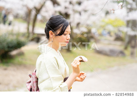 A woman enjoying eating while sightseeing in Kyoto A woman enjoying eating while sightseeing in Kyoto 82854988