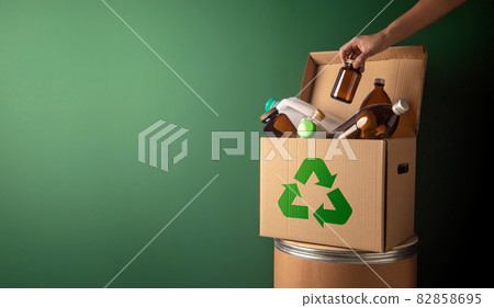 Climate and Environmentally Conservation Concept. Recycling Corrugated Box with Full of Plastic and Glass Bottle againts the Green Wall. Zero Waste, Reduce Plastic. Environment, Ecology Care and 82858695