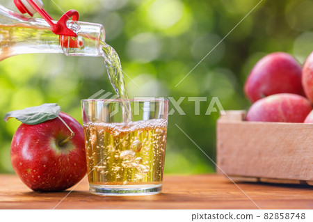 apple cider or juice pouring in glass from bottle apple cider or juice pouring in glass from bottle 82858748