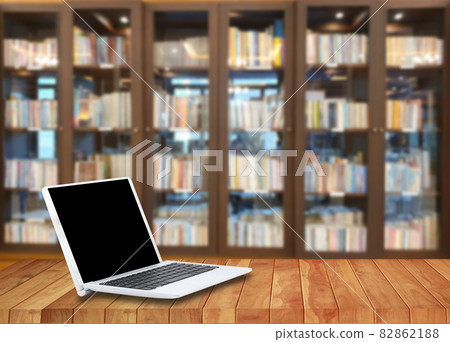 Laptop on a wooden floor in the library Laptop on a wooden floor in the library 82862188